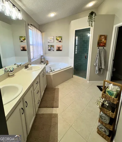 a spacious bathroom with double vanity and a tub