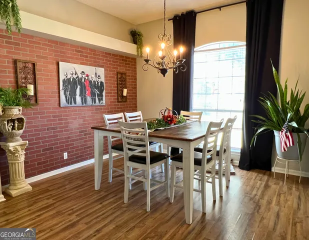 a dining room with furniture potted plants and wooden floor