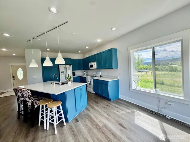a kitchen with a table chairs sink and cabinets