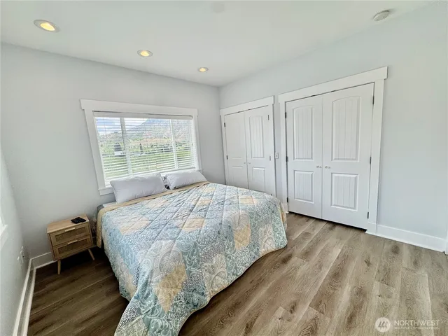 a bed sitting in a spacious bedroom next to a window
