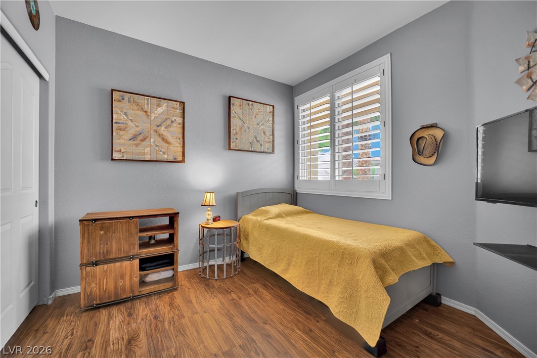 1724 Millstream Way Henderson, NV 89074 - Photo 19 of 60 Hardwood-style flooring extends across this naturally illuminated bedroom with a window featuring shutters.