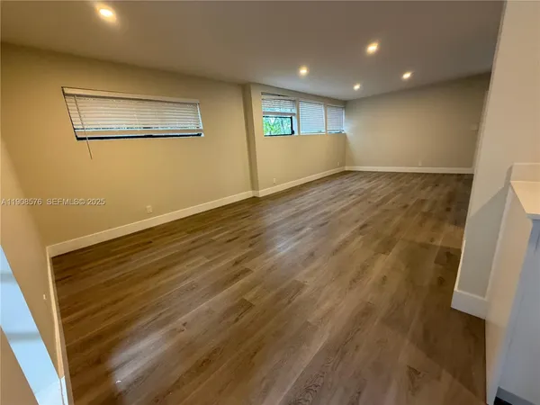 a view of empty room with wooden floor