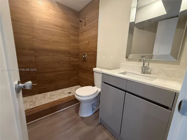 a bathroom with a sink a toilet and shower