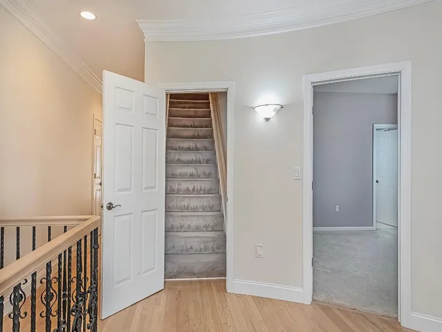 a view of a hallway with wooden floor and entryway