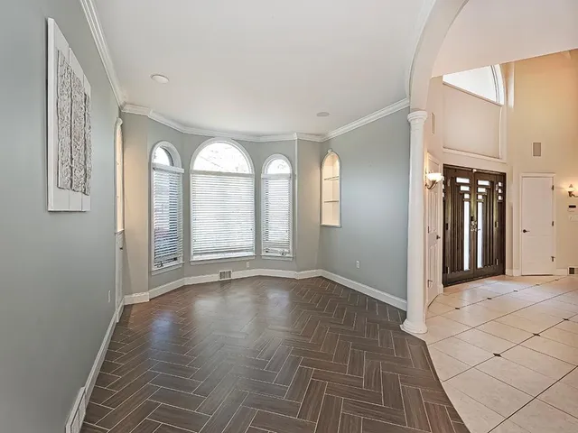 a view of an empty room with glass door and a window