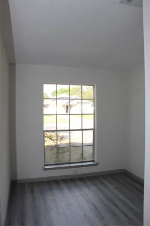 a view of an empty room with wooden floor