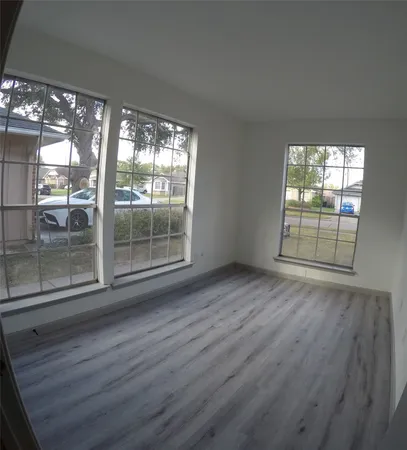 a view of a room with wooden floor and windows
