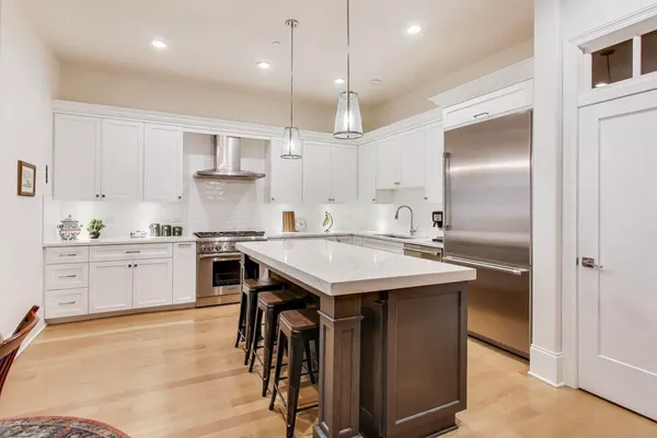 a kitchen with a table chairs refrigerator and microwave
