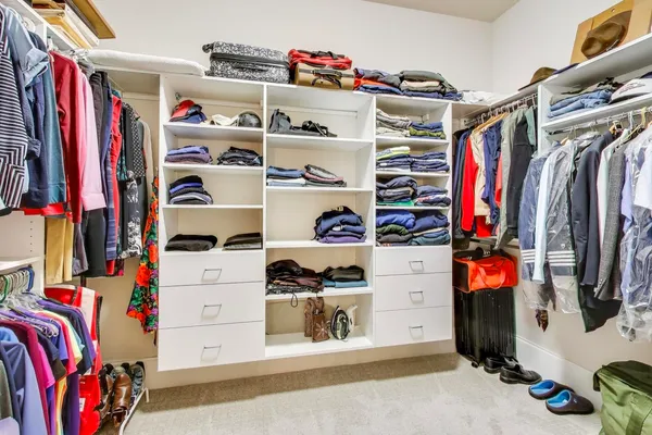 a bedroom with a bed chairs and a large window