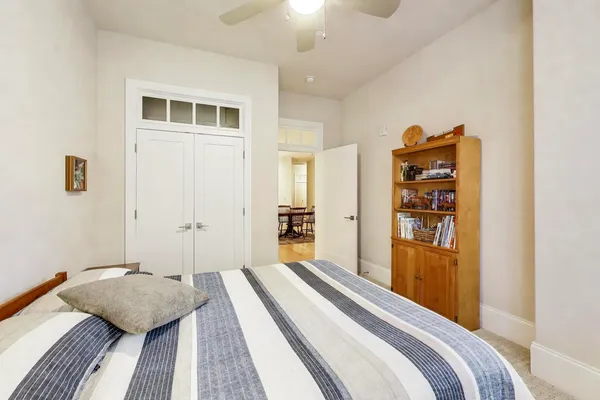a living room with furniture a bookshelf and a window