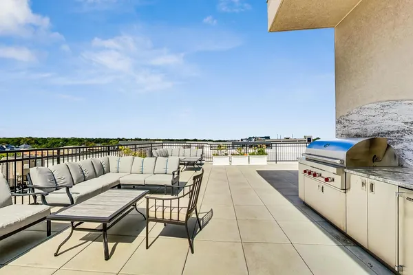 a view of a roof deck with couches and potted plants