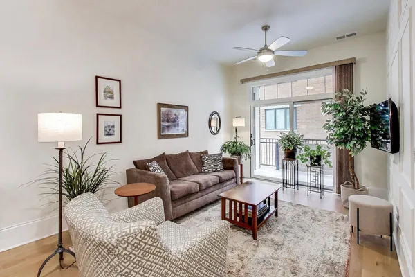 a living room with patio furniture and a wooden floor