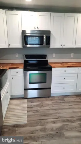 a kitchen with granite countertop white cabinets and a stove