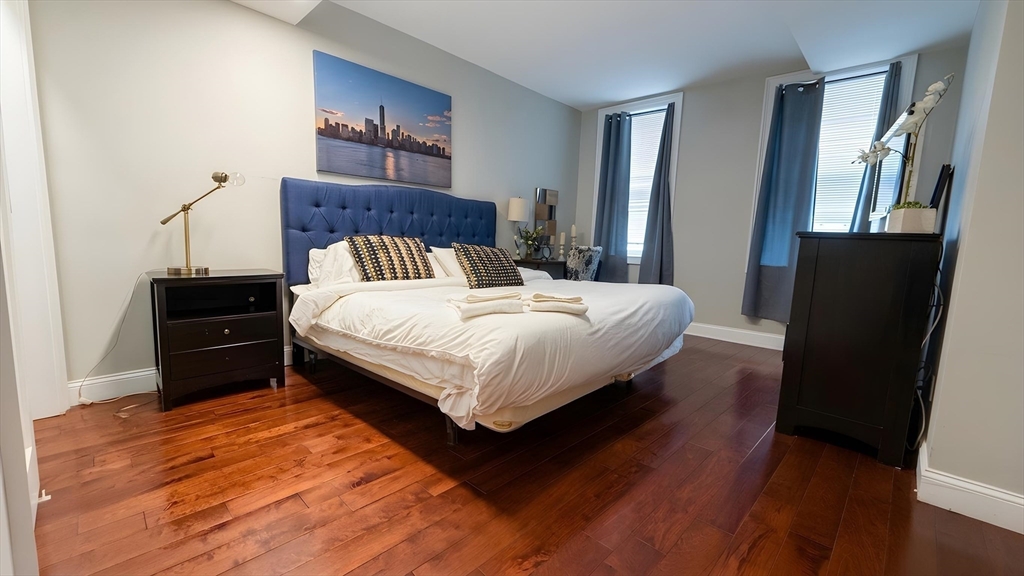 a bedroom with a bed and wooden floor