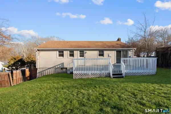 a view of a house with a yard and deck