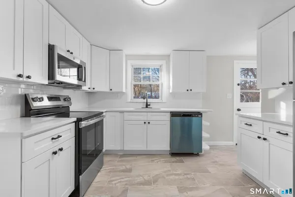 a kitchen with stainless steel appliances granite countertop a sink and dishwasher a stove top oven with white countertops