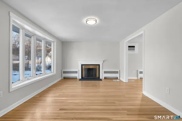 a view of a livingroom with wooden floor and a fireplace