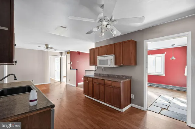a kitchen with stainless steel appliances granite countertop a sink dishwasher stove and oven with wooden floor