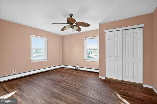 a view of room with hardwood floor and ceiling fan