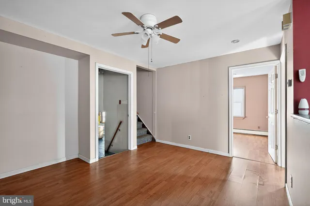 an empty room with closet and a ceiling fan