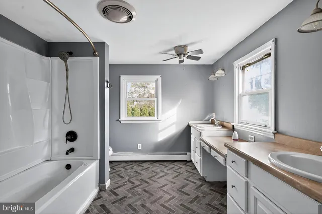 a bathroom with a tub sink and mirror