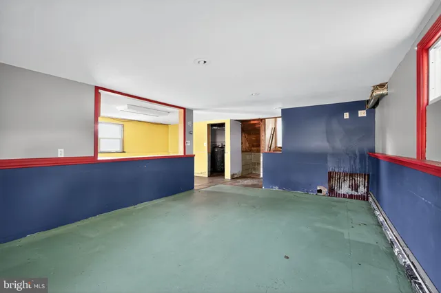 a view of an empty room with window and stairs