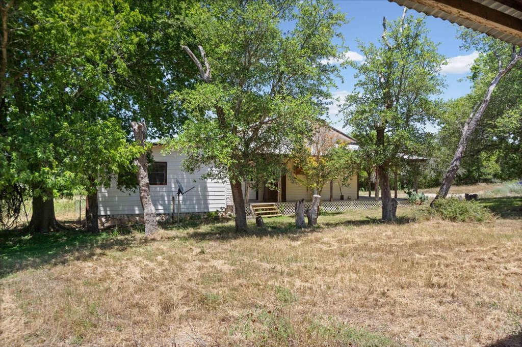 555 Harmon Hills Road, Unit A Dripping Springs, TX 78620 - Photo 28 of 29 Mature trees shade a charming residence, nestled in a tranquil natural setting.