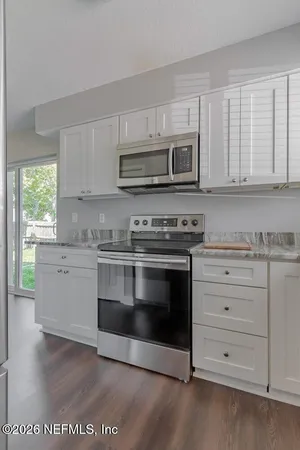 a kitchen with stainless steel appliances granite countertop a stove microwave and cabinets