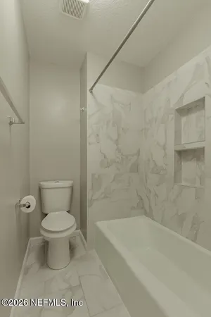 a bathroom with a toilet and a bathtub