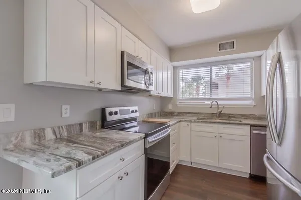 a kitchen with stainless steel appliances granite countertop a sink stove and cabinets