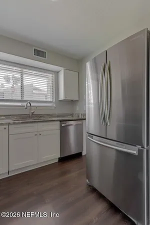 a kitchen with stainless steel appliances granite countertop a sink a refrigerator and a stove
