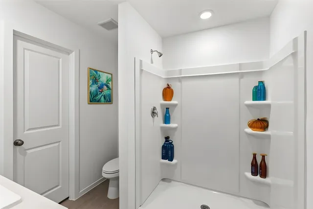 a bathroom with a toilet and a shower