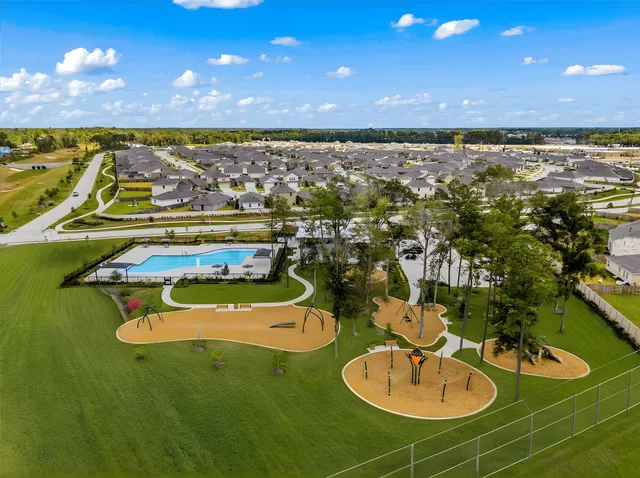 an aerial view of a pool with lawn chairs