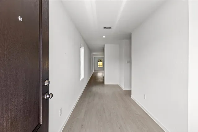 a view of a hallway with wooden floor