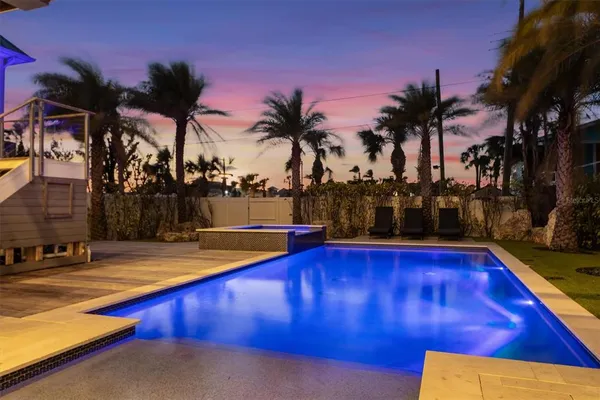 a view of a house with a yard and palm trees