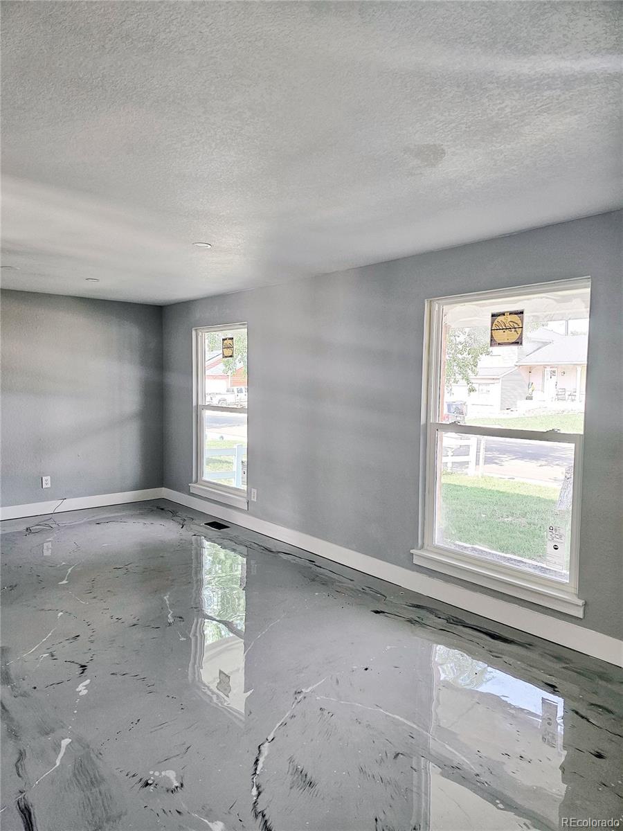 4716 Freeport Way Denver, CO 80239 - Photo 5 of 29 an empty room with windows