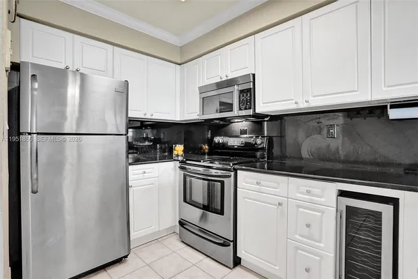 a white refrigerator freezer and a stove sitting inside of a kitchen