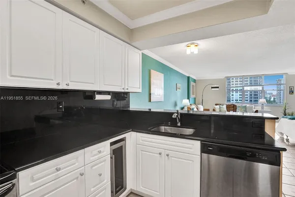 a kitchen with granite countertop white cabinets and black appliances