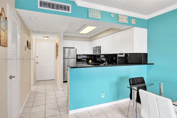 a view of a kitchen with fridge and window