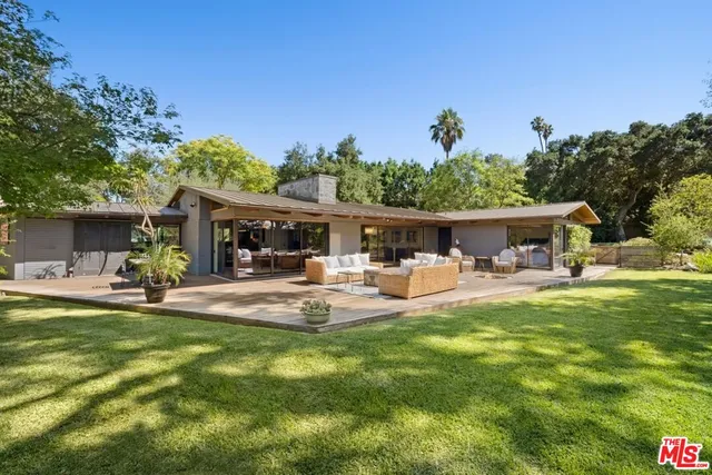 a living room with furniture a chandelier fan and a window