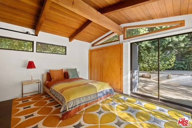 a view of a patio with couches table and chairs under an umbrella
