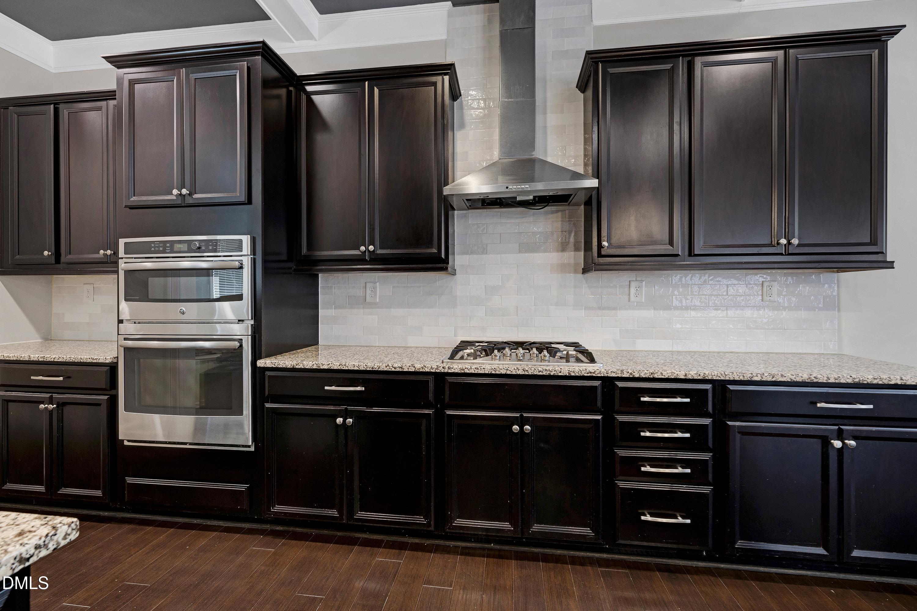 212 Mystic Pine Place Apex, NC 27539 - Photo 11 of 67 a kitchen with stainless steel appliances wooden cabinets and a stove top oven