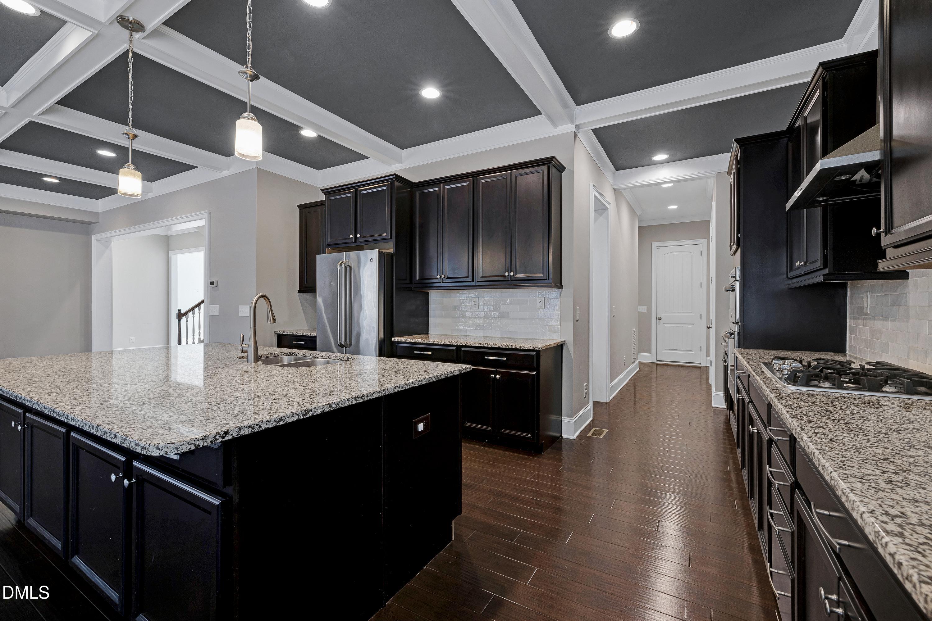 212 Mystic Pine Place Apex, NC 27539 - Photo 13 of 67 a kitchen with stainless steel appliances granite countertop a sink a stove and a wooden floors