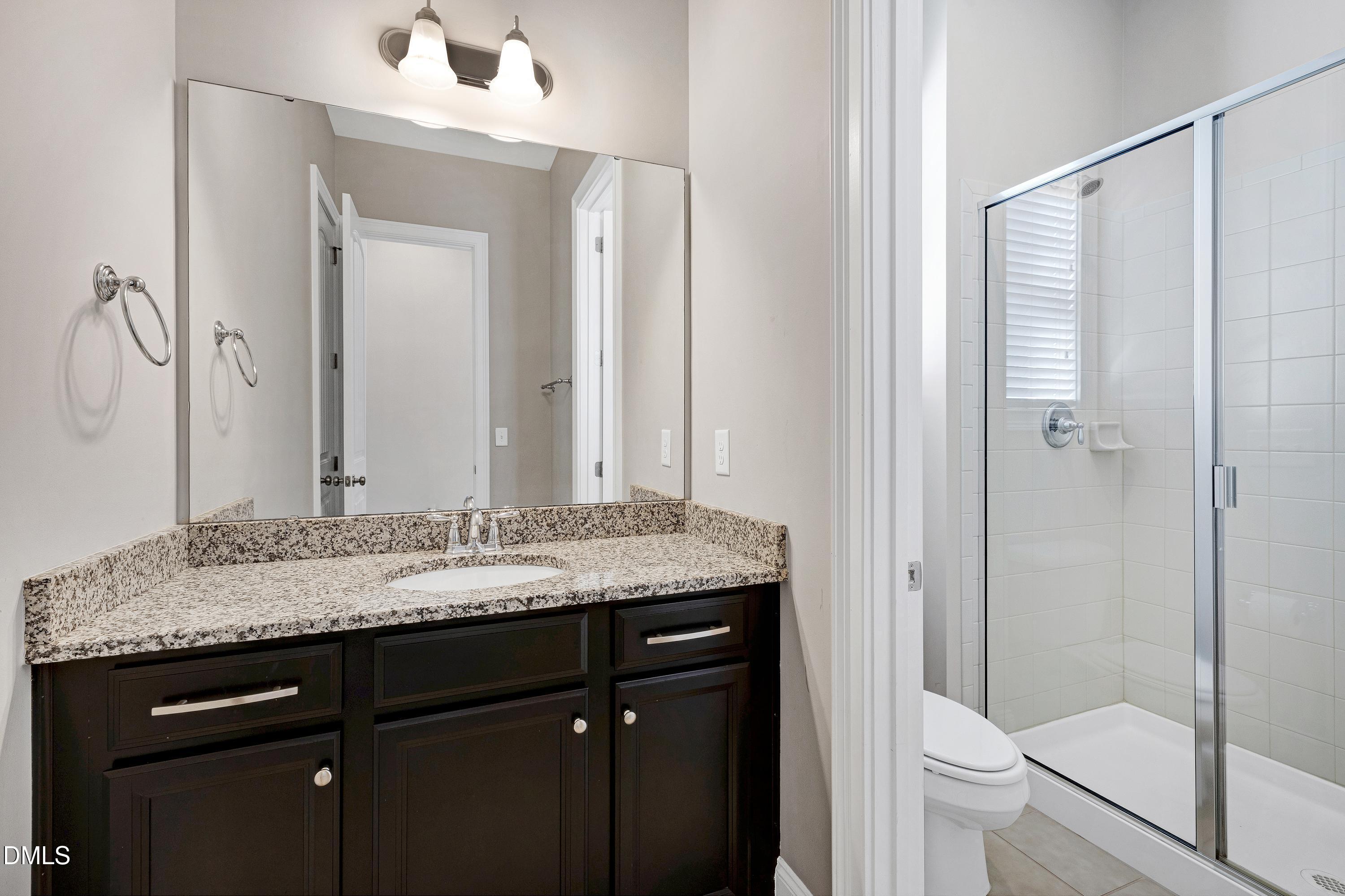 212 Mystic Pine Place Apex, NC 27539 - Photo 35 of 67 a bathroom with a granite countertop sink toilet and shower