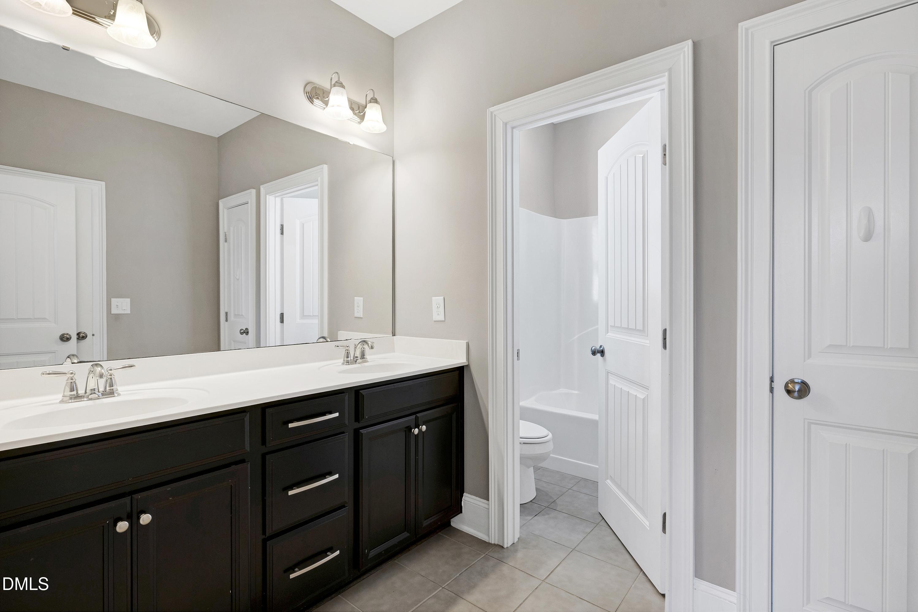 212 Mystic Pine Place Apex, NC 27539 - Photo 41 of 67 a bathroom with a double vanity sink a toilet and a mirror
