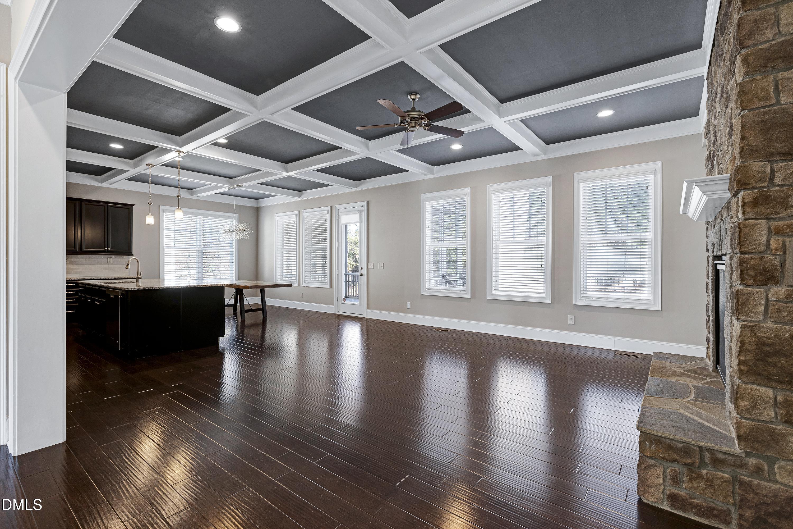 212 Mystic Pine Place Apex, NC 27539 - Photo 5 of 67 a view of an empty room with wooden floor and a kitchen