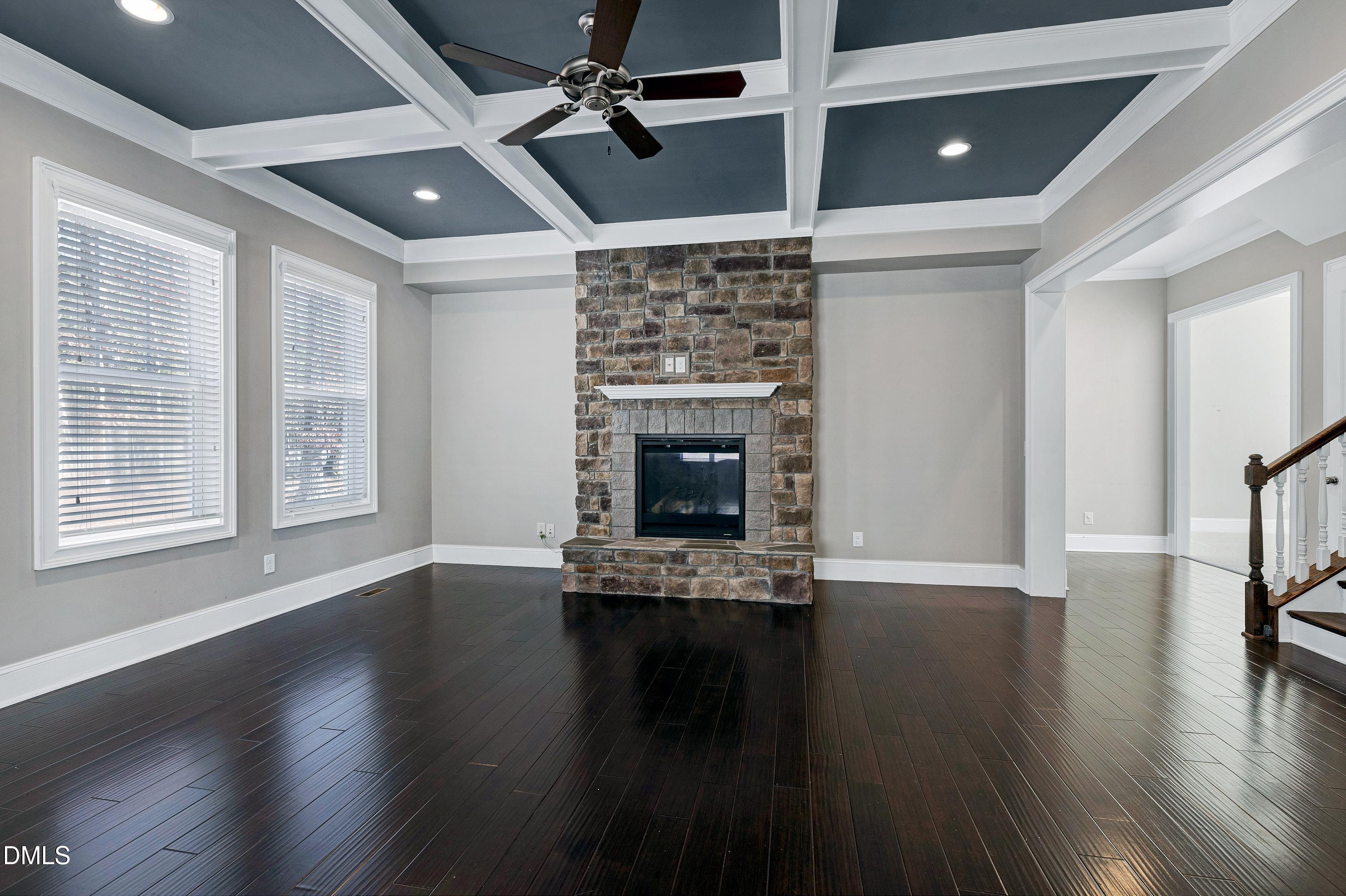 212 Mystic Pine Place Apex, NC 27539 - Photo 6 of 67 a view of an empty room with wooden floor fireplace and a window