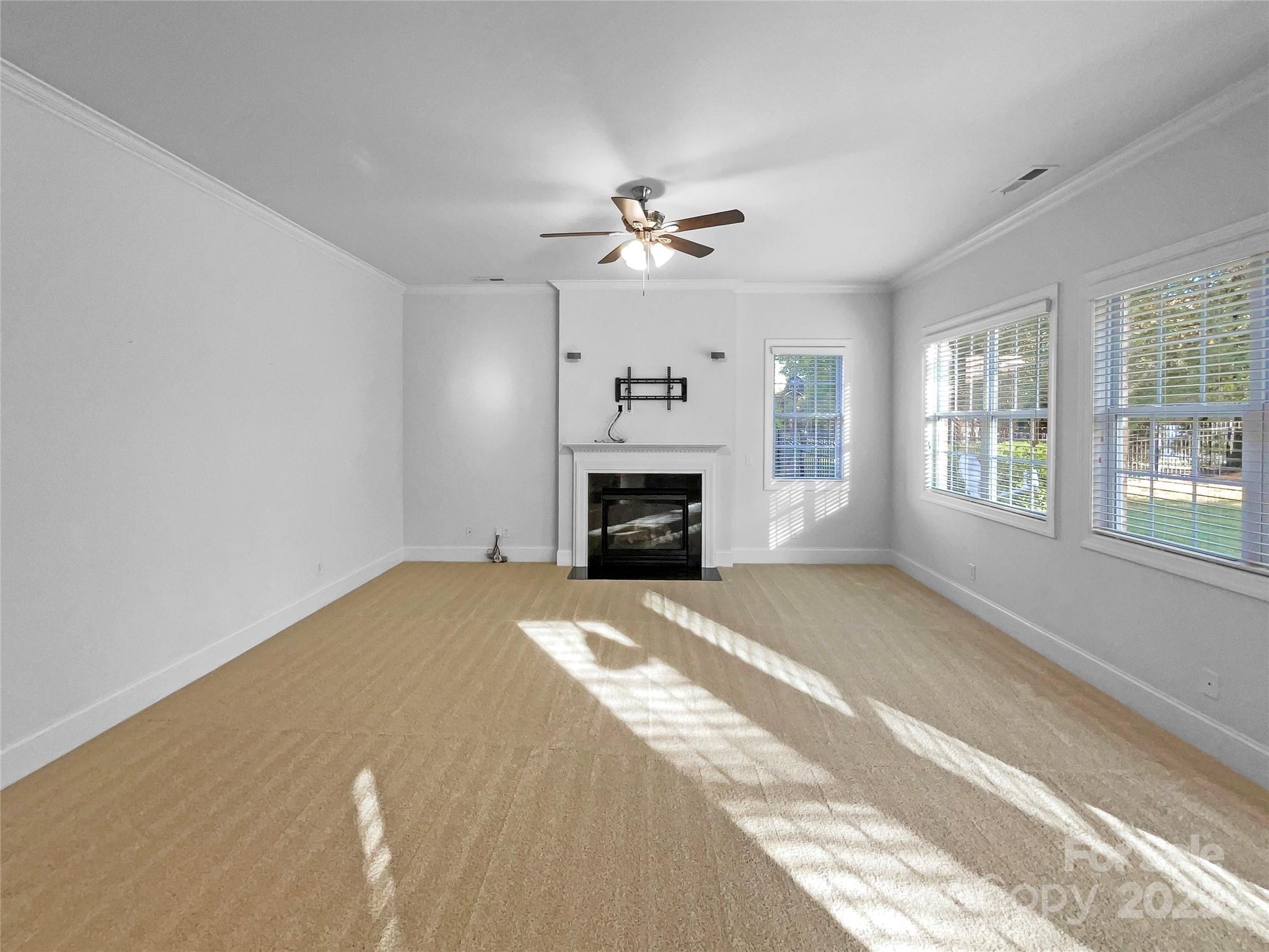 6615 Springs Mill Road Charlotte, NC 28277 - Photo 13 of 23 a view of a livingroom with a fireplace a ceiling fan and windows