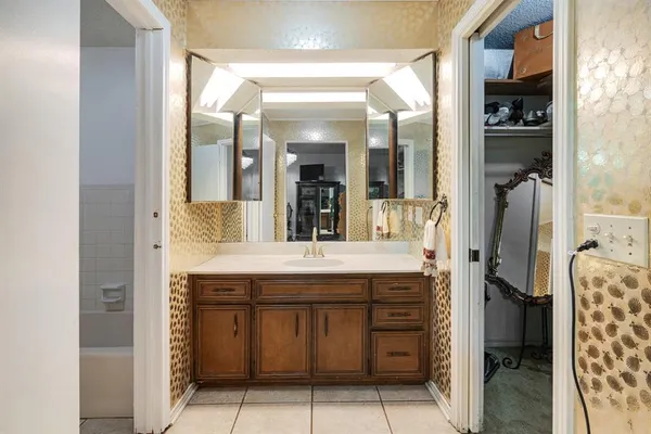 a bathroom with a granite countertop sink a mirror and a shower