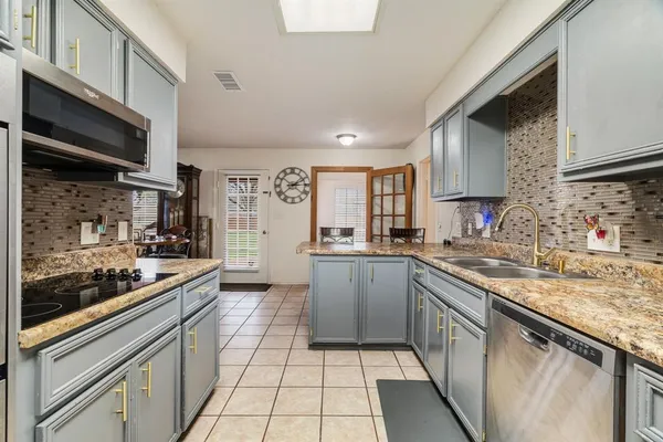 a kitchen with stainless steel appliances granite countertop a sink and cabinets